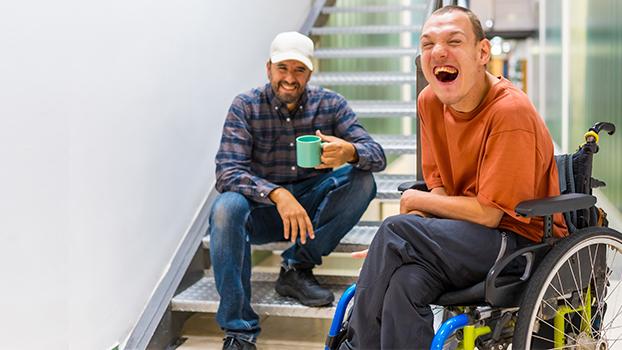 Support worker and participant laughing together